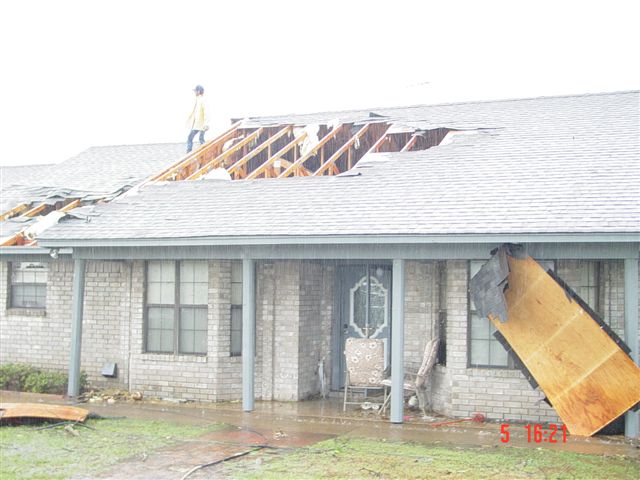 Plywood pushed up against the house, roof damage from the storm.